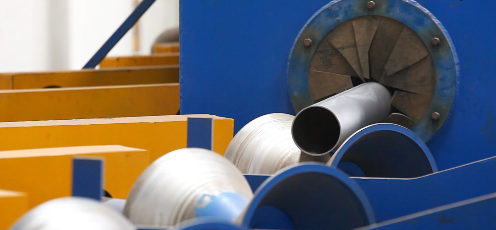 Automated shot blasting machine for conveyor idler tubes at JIENASI factory.